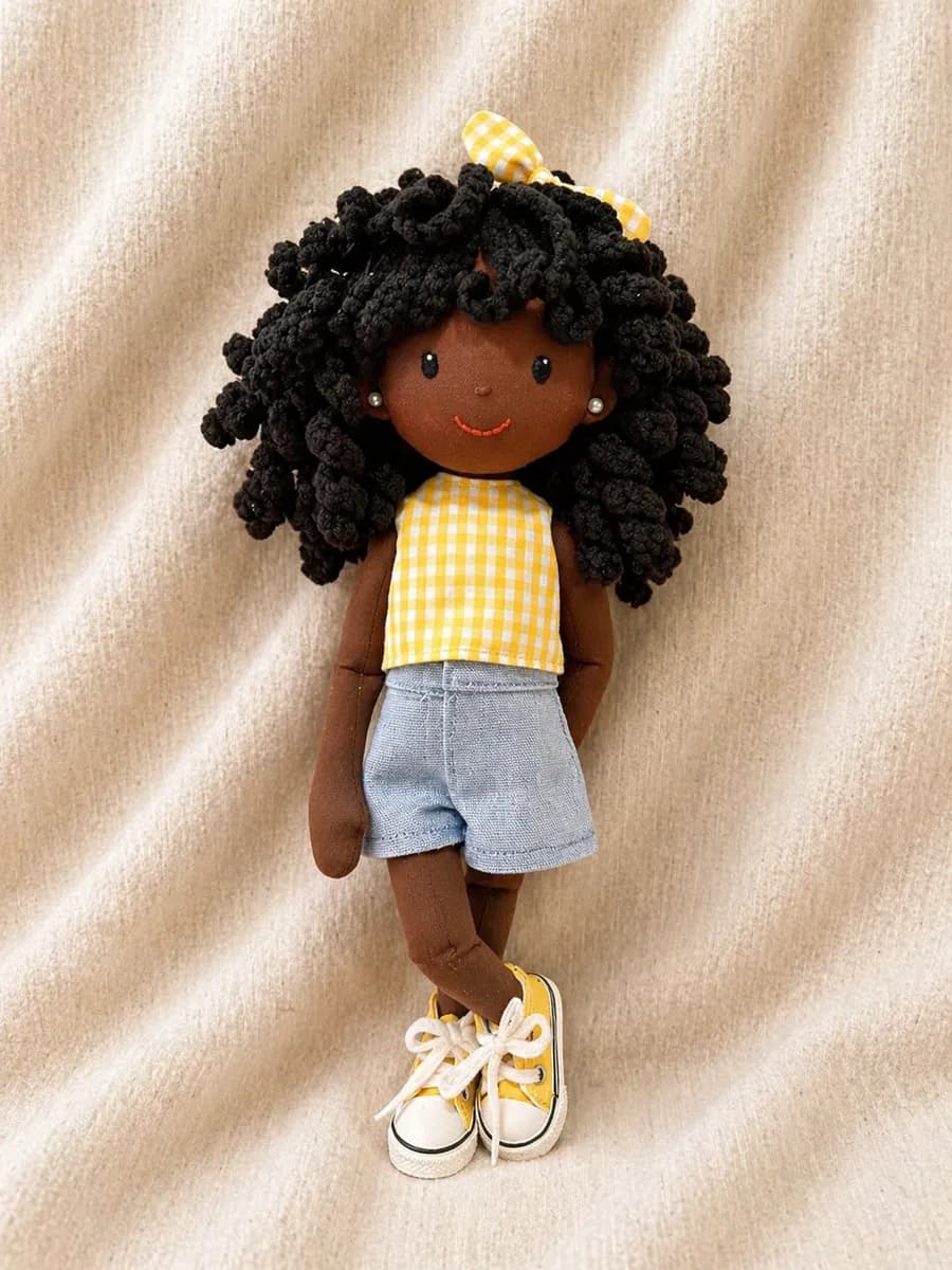 Boneca de pano de cabelo afro com blusa amarela xadrez e shorts jeans