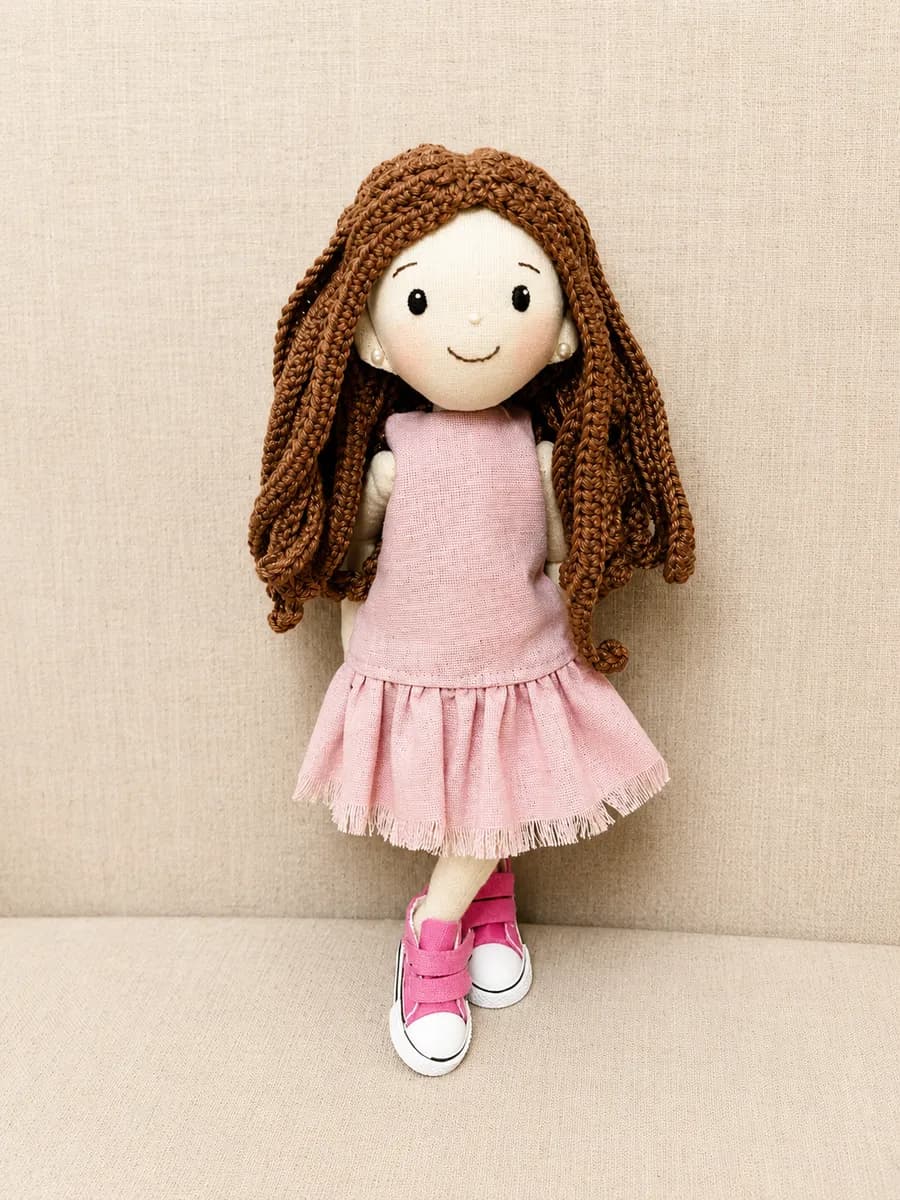 Boneca de pano com vestido rosa e cabelo castanho