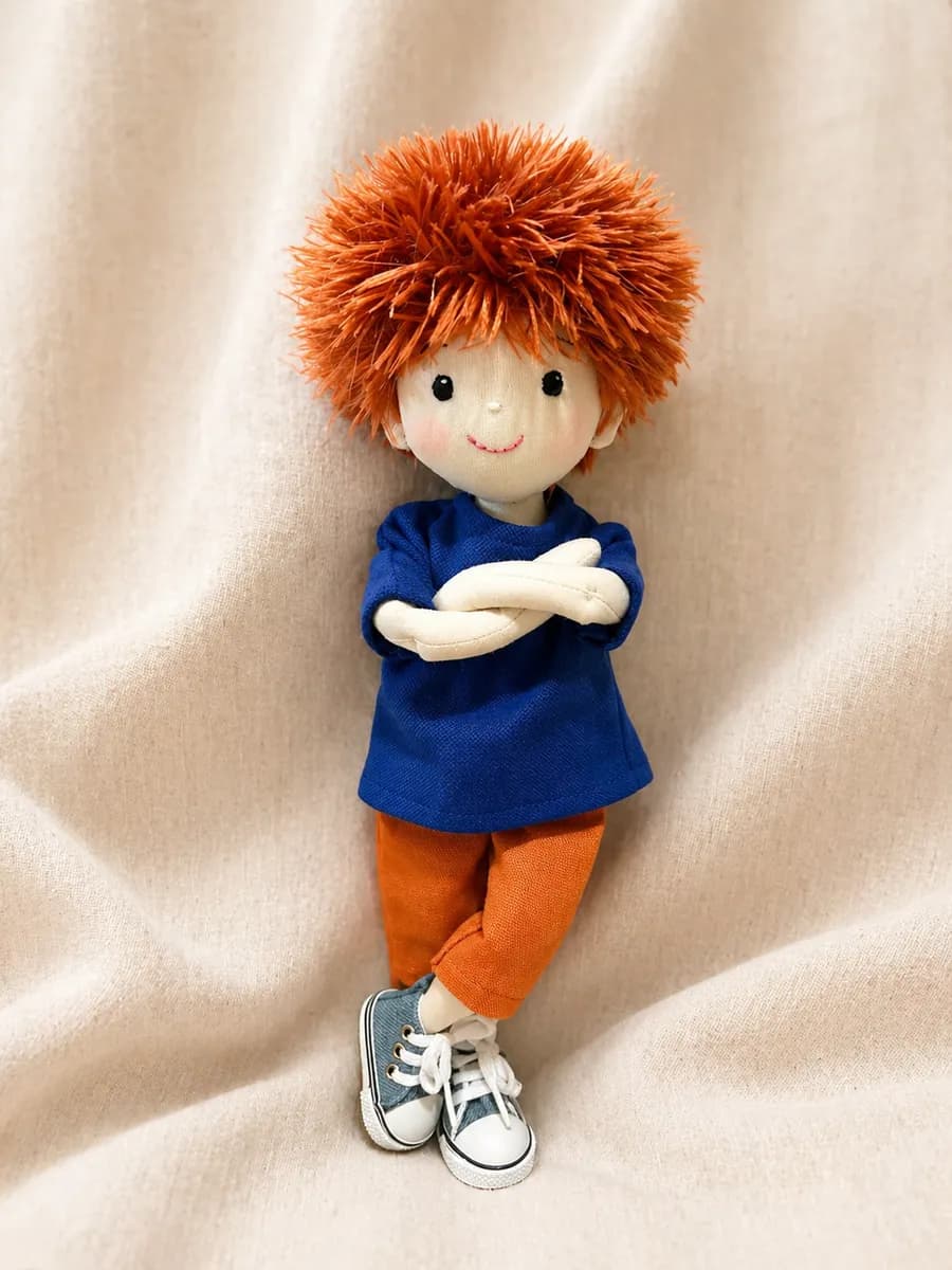 Boneco de pano ruivo com camiseta azul e calça laranja